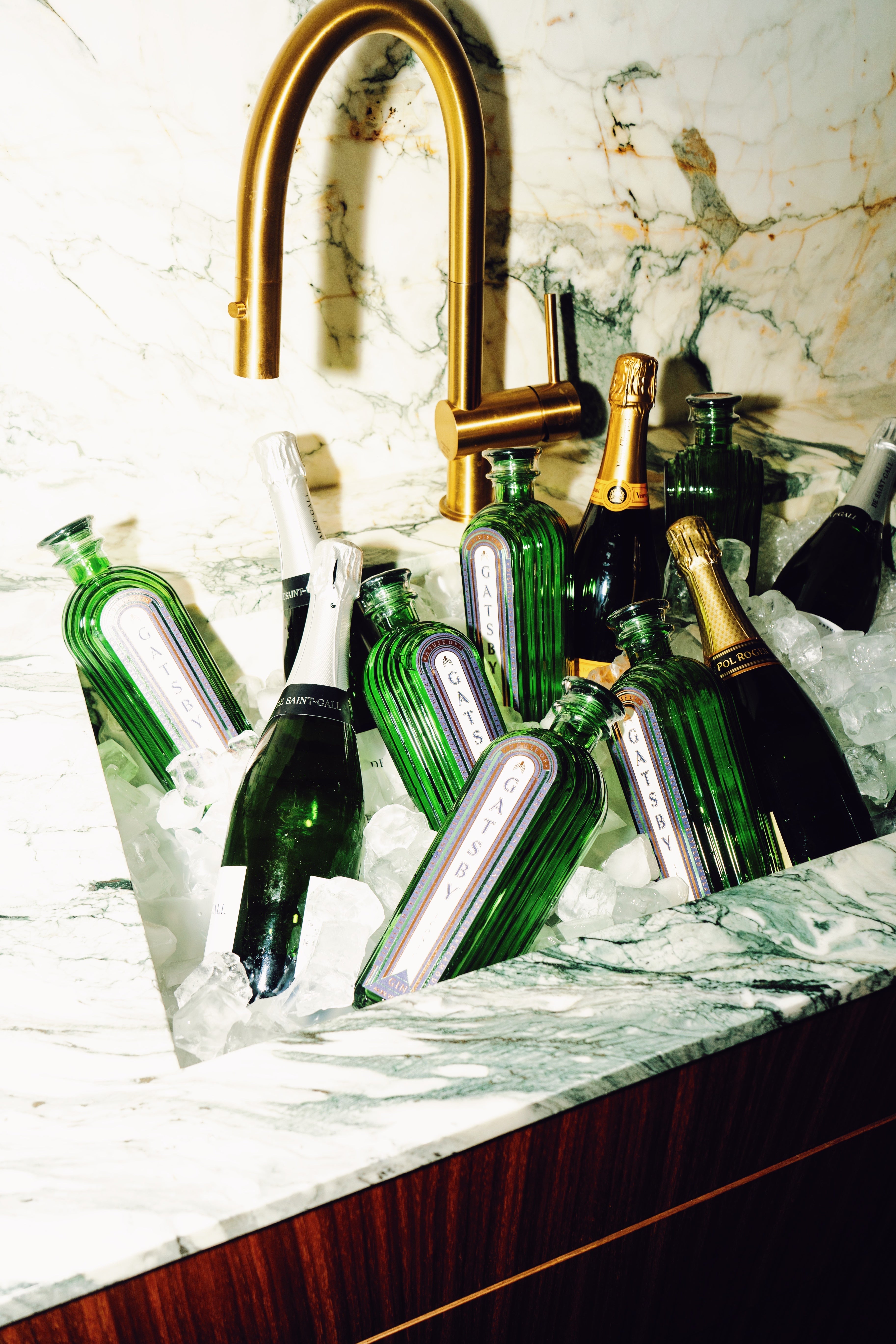 Gatsby Gin bottles chilling on ice in a marble sink with gold faucet